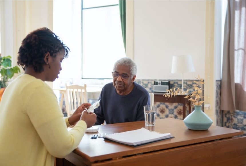 Nursing home staff providing medication assistance to senior man