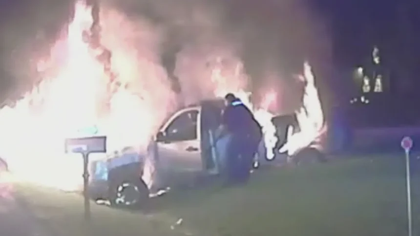woman rescued by Michigan police officer from burning pickup truck.