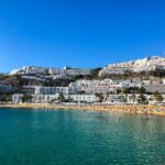 a crowded beach and buildings on a mountain in Gran Canaria